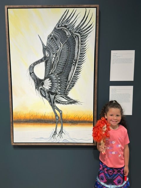 A Focal Point Artistry Indigenous art exhibition set up in a community space, such as a library or school hall, making Woodland style art accessible to the public.