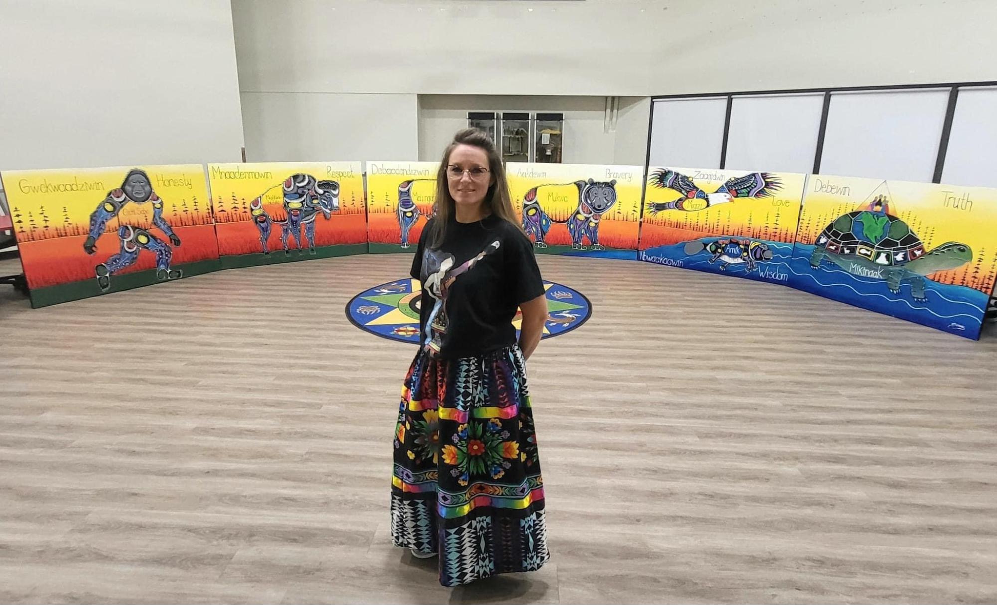 Jessica Somers presenting a vibrant Woodland style painting, discussing the use of spirit lines, Wabanaki motifs, and color theory in Indigenous contemporary art.